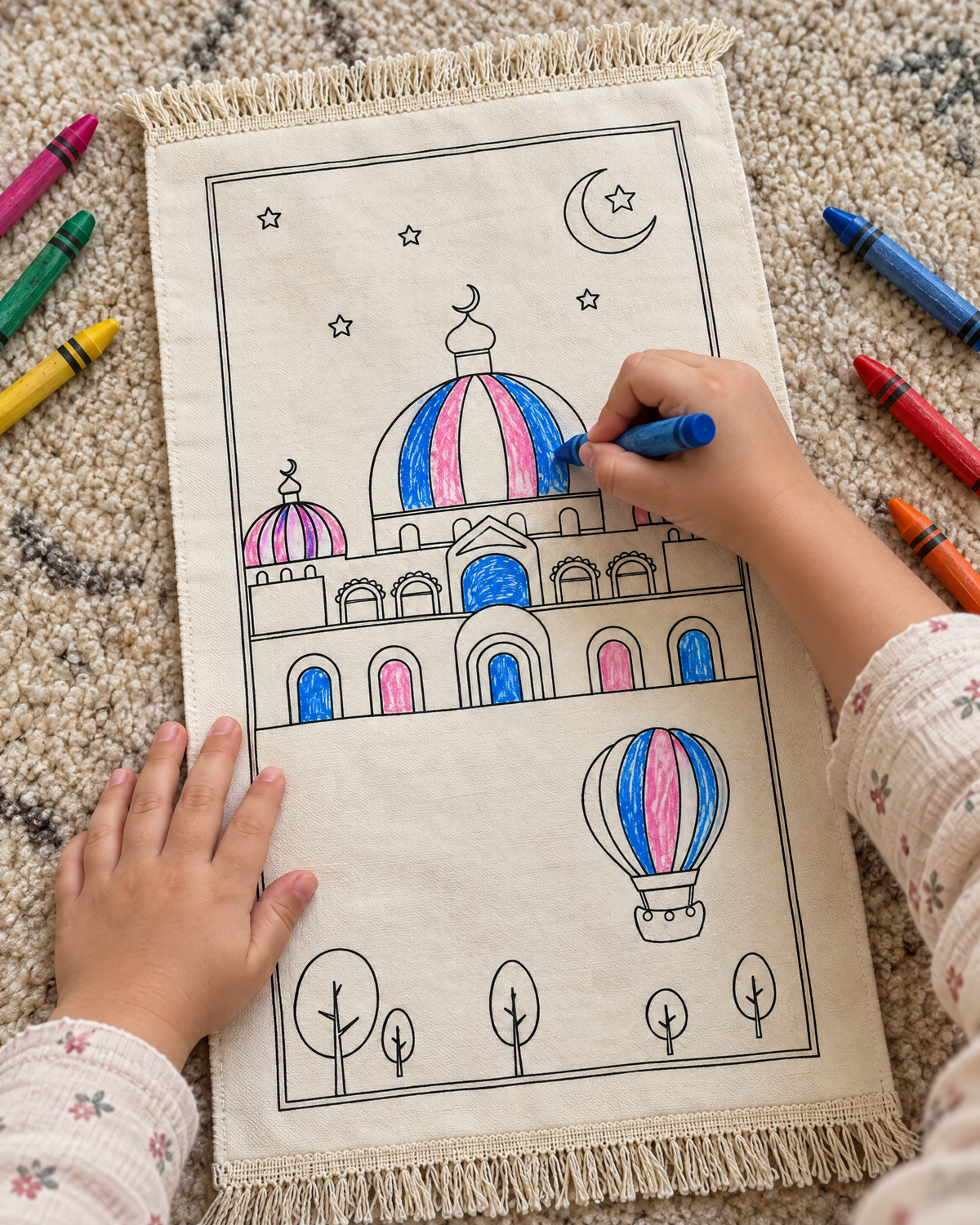 Child's hands colouring the Color and pray prayer mat with crayons